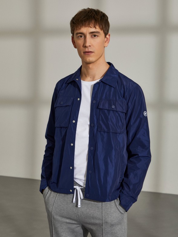 Man's blue technical jacket with pockets