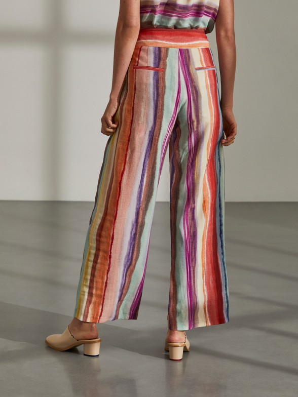 Woman's flowing trousers with colourful stripe pattern